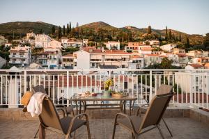 a table and chairs on a balcony with a city at Dioni, Central Luxury Apartment in Samos