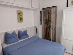 a bedroom with a blue bed with blue pillows at Timounyan T2 centre ville au calme Animaux acceptés in Arcachon