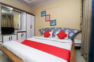 丹巴德Super Hotel O Akash Regency的卧室里有一张大床，配有红色枕头