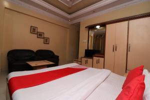 丹巴德Super Hotel O Akash Regency的一间带床、沙发和电视的卧室
