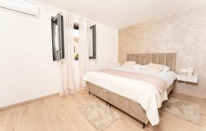 a white bedroom with a large bed and a window at Beautiful Home In Labin in Labin