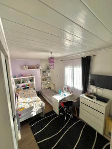 Un dormitorio con una cama, un escritorio y una computadora. en Vecan, en Grisy-Suisnes