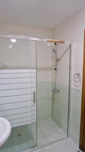 a glass shower in a bathroom with a sink at Byala Vista Beach Apartments D - Бяла Виста Бийч Апартментс Д in Byala