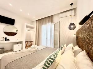 a bedroom with a large bed with white pillows at Acropolis in Parikia