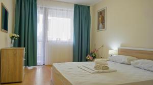 a bedroom with a large bed with green curtains at Byala Vista Beach Apartments D - Бяла Виста Бийч Апартментс Д in Byala +34 photos