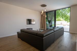 a living room with a black leather couch at Villa ELENA in Međugorje