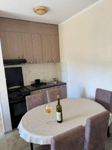 a bottle of wine sitting on a table in a kitchen at Apartman Tafra 3 in Igalo