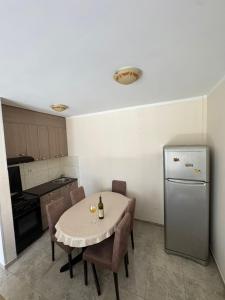 a small kitchen with a table and a refrigerator at Apartman Tafra 3 in Igalo