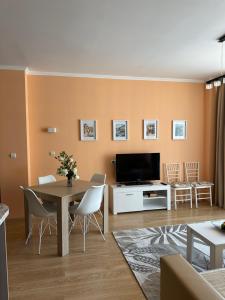 a living room with a table and a tv at 2 bedroom apartment komplex Andalusia Elenite with terrasa and sea in Sveti Vlas