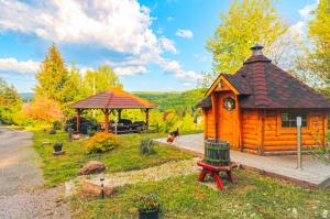 a log cabin with a gazebo and a house at Cabane, Kota Gri'hôtes in Fougerolles