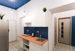 Una cocina con gabinetes azules y blancos y un fregadero. en Dom Gościnny Lublin, en Lublin