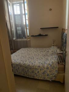 a small bedroom with a bed and a window at Πόλη της Κέρκυρας διαμέρισμα in Corfu
