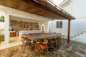 a dining room with a large wooden table and chairs at KUKI BEACH - Luxury Beachfront Villa in Ahangama in Ahangama