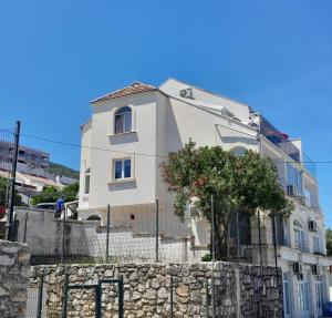 a white house behind a stone wall at Rosemary Terrace Krasici in Krasici