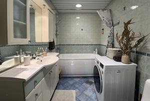 a bathroom with a sink and a washing machine at 100 square meter 4-room central smart apt in Tallinn +30 photos