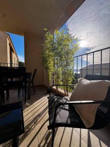 a balcony with a chair and a table on a balcony at Appartement neuf, proche des plages et centre ville in Saint-Florent +6 photos