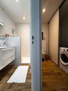 a bathroom with a sink and a washing machine at Appartement neuf, proche des plages et centre ville in Saint-Florent