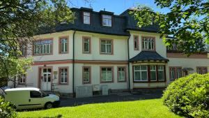 a van parked in front of a large house at Mountain Peak Apartment in Tatranská Lomnica +15 photos