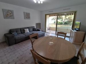 a living room with a table and a couch at air-conditioned apartment with pool plus beach shuttle in Mandelieu-La Napoule