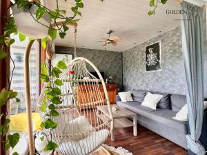 een schommel in een woonkamer met een bank bij Le Balcon des Alpes - Confort et Vue Unique in Bonneville +17 foto's