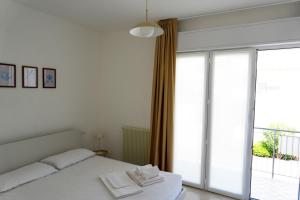 sypialnia z łóżkiem i dużym oknem w obiekcie Dainese Apartments, Casa Abigail w mieście Lido di Jesolo