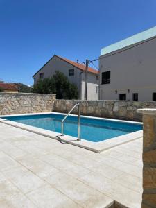 a swimming pool in front of a building at Palada House with a Private Pool in Marina