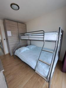 a bunk bed in a small room with a bunk bedscribed at Panoramisch appartement tussen zee ,bos en de duinen in De Panne