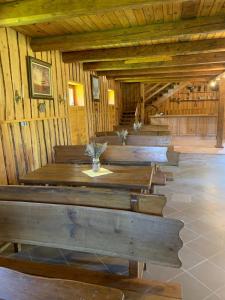 a row of wooden tables in a wooden building at Zacisze Ośmiu Stawów Siekierczyna - The Quort of Eight Pounds 