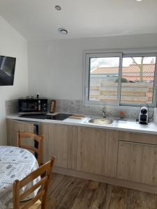 a kitchen with a sink and a window at Le Clos qui Clôt in Le Fenouiller