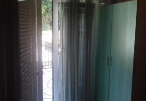 a window with white curtains in a room at Studio Terasa in Kravlja