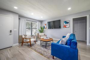 Modern 2BR DownTown Home with King Bed, Long Stays, WiFi, Netflix في أورلاندو: غرفة معيشة مع أريكة زرقاء وطاولة