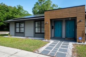 Modern 2BR DownTown Home with King Bed, Long Stays, WiFi, Netflix في أورلاندو: منزل صغير بأبواب زرقاء ورصيف