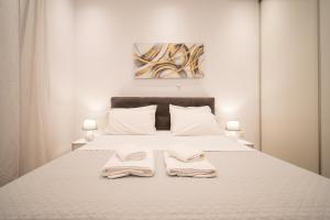 a bedroom with a white bed with two towels on it at Kyra's Luxury Suites 4 in Chios +24 photos