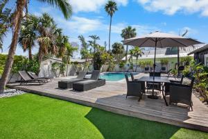 a wooden deck with a table and umbrella next to a pool at Villa #4 Sand Dollar in Holmes Beach