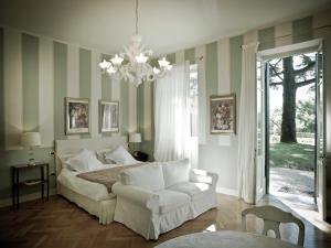 a bedroom with a bed and a couch and a chandelier at Residenza Borgo 27 in Grezzana