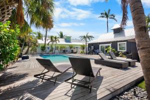 a deck with chairs and a swimming pool at Villa #6 Starfish in Holmes Beach