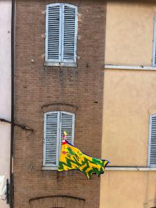 flaga pływająca przed ceglanym budynkiem w obiekcie La Campanina-nel cuore di Siena e della contrada w Sienie