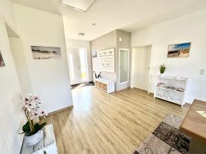 an empty living room with wooden floors and white walls at Villa Weißer Schwan in Trent