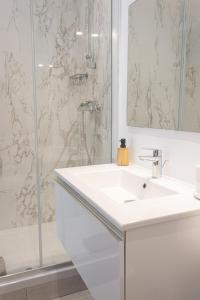 a white bathroom with a sink and a shower at Le Refuge des Vignes - Centre Ville - Elégant in Bordeaux +10 photos