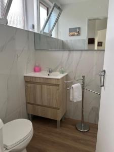 a bathroom with a sink and a toilet and a mirror at Sintra Sol - Apartamentos Turisticos in Sintra