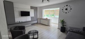 a living room with a clock on the wall at ILONA APARTAMENT 3 camere in Râmnicu Vâlcea