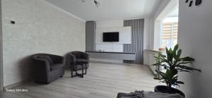 a living room with two chairs and a television at ILONA APARTAMENT 3 camere in Râmnicu Vâlcea