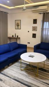 Una sala de estar con un sofá azul y una mesa. en Cozy, Elegant, Central, Peaceful, en Cotonou