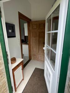 a bathroom with a glass door and a kitchen at Ferien auf traumhaftem Resthof in Twedt