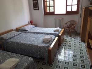 a room with three beds and a chair at Villa Maria in Maruggio