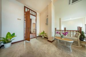 a living room with a couch and a table with flowers at Bigcountry Villa Ayutthaya in Phra Nakhon Si Ayutthaya