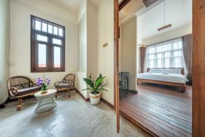 a large room with a bed and a bed and a table at Bigcountry Villa Ayutthaya in Phra Nakhon Si Ayutthaya