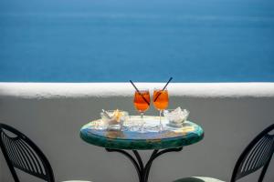 two glasses on a table on a balcony at Hotel Costa Diva in Praiano