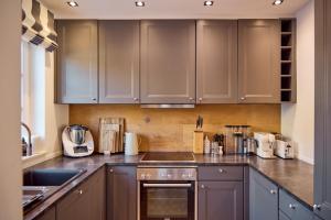 a kitchen with gray cabinets and a counter top at Reethüs Keitum mit Kamin und Südgarten in direkter Wattnähe in Keitum
