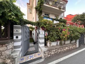 a building with potted plants on the side of a street at BlueSkyLite in Taormina